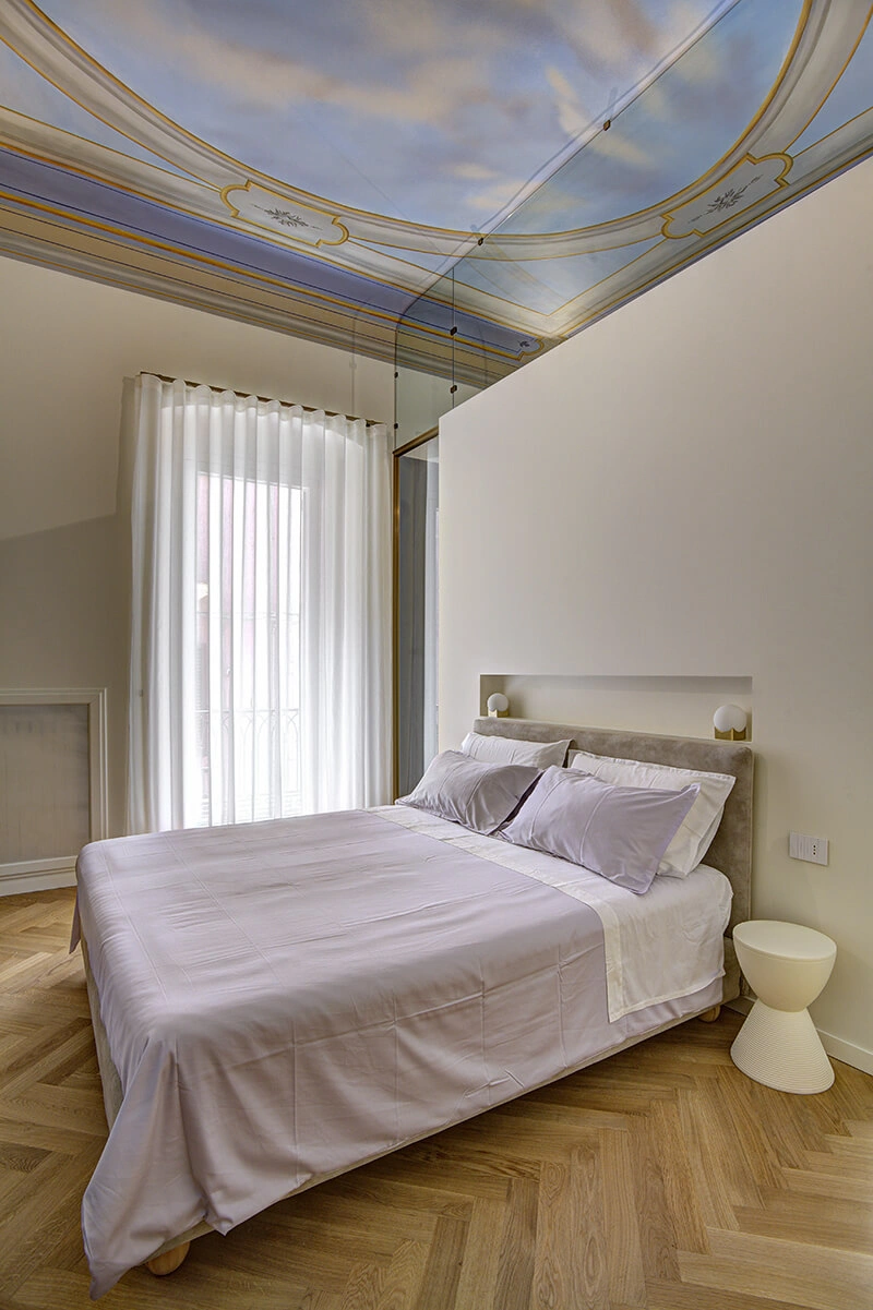 Letto e cielo dipinto sul soffitto della Camera Cielo del B&B a Barletta.
